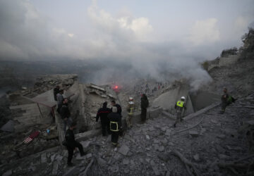 FILE - Rescue workers and people gather on the rubble of a house hit in an Israeli airstrike in Baalchmay village east of Beirut, Lebanon, on Nov. 12, 2024. (AP Photo/Hassan Ammar, File)