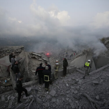 FILE - Rescue workers and people gather on the rubble of a house hit in an Israeli airstrike in Baalchmay village east of Beirut, Lebanon, on Nov. 12, 2024. (AP Photo/Hassan Ammar, File)