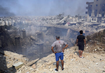 FILE - People check a damaged building at the site of an Israeli airstrike in Choueifat, south east of Beirut, on Sept. 28, 2024. (AP Photo/Hussein Malla, File)