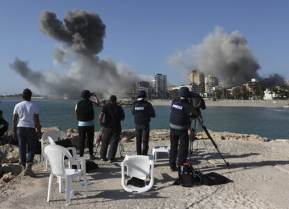 FILE - Journalists film as smoke rises from buildings hit in Israeli airstrikes in Tyre, southern Lebanon, on Oct. 28, 2024. (AP Photo/Mohammed Zaatari, File)