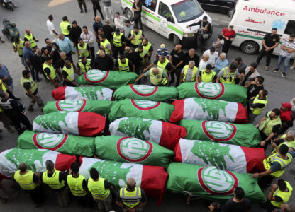 FILE - Paramedics stand next to the coffins of people who were killed in an Israeli airstrike in Barja, during their funeral procession in Tyre, southern Lebanon, on Nov. 7, 2024. (AP Photo/Mohammed Zaatari, File)