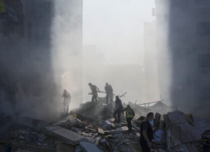 FILE - Civil defense workers extinguish a fire as smoke rises from the site of an Israeli airstrike in Tayouneh, Beirut, Lebanon, on Nov. 15, 2024. (AP Photo/Hassan Ammar, File)