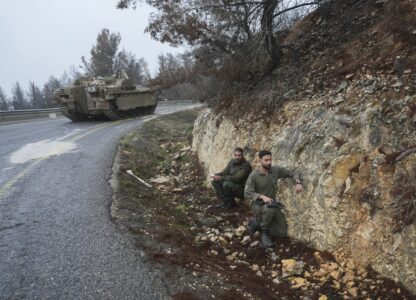 Israeli soldiers take cover on the side of the road during an alert of incoming rockets, near Kiryat Shmona, northern Israel Sunday Nov. 24, 2024. (AP Photo/Ohad Zwigenberg)