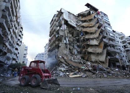 A Civil Defense worker uses a skid loader to remove the rubble in front of a destroyed building that was hit Sunday night in an Israeli airstrike in Dahiyeh, in the southern suburb of Beirut, Lebanon, Monday, Nov. 25, 2024. (AP Photo/Hussein Malla)