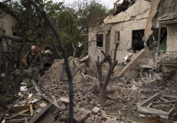 A member of the Israeli security forces inspects an impact site following a rocket fired from Lebanon hit an area in Rinatya, outskirts of Tel Aviv, Israel, Sunday, Nov. 24, 2024. (AP Photo/Leo Correa)