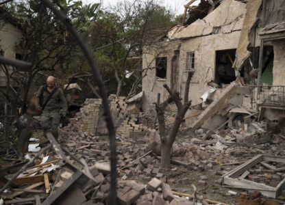 A member of the Israeli security forces inspects an impact site following a rocket fired from Lebanon hit an area in Rinatya, outskirts of Tel Aviv, Israel, Sunday, Nov. 24, 2024. (AP Photo/Leo Correa)