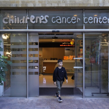 Mohammad Mousawi, 8, a displaced boy from the southern suburb of Beirut who suffers from leukaemia, steps out the entrance of the Children's Cancer Center of Lebanon, in Beirut, Lebanon, Friday, Nov. 15, 2024. (AP Photo/Hussein Malla)