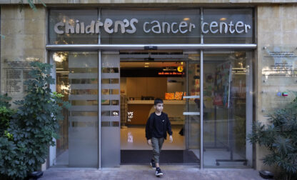 Mohammad Mousawi, 8, a displaced boy from the southern suburb of Beirut who suffers from leukaemia, steps out the entrance of the Children's Cancer Center of Lebanon, in Beirut, Lebanon, Friday, Nov. 15, 2024. (AP Photo/Hussein Malla)