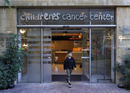 Mohammad Mousawi, 8, a displaced boy from the southern suburb of Beirut who suffers from leukaemia, steps out the entrance of the Children's Cancer Center of Lebanon, in Beirut, Lebanon, Friday, Nov. 15, 2024. (AP Photo/Hussein Malla)