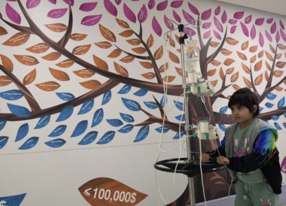 Carol Zeghayer, 9, who suffers from leukaemia, carries her dose treatment as she walks at a corridor inside the Children's Cancer Center of Lebanon, in Beirut, Lebanon, Friday, Nov. 15, 2024. (AP Photo/Hussein Malla)