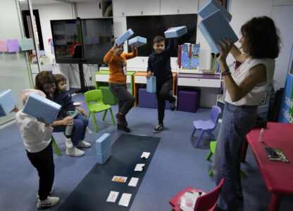 Children who suffers from cancer, enjoy at a playroom with a volunteer ahead of their treatments at the Children's Cancer Center of Lebanon, in Beirut, Lebanon, Friday, Nov. 15, 2024. (AP Photo/Hussein Malla)