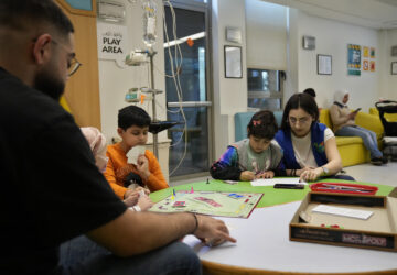 Carol Zeghayer, 9, second right, a girl who suffers from leukaemia, attends with a volunteer who offers her a compassionate care and entertainment session ahead of her treatment at the Children's Cancer Center of Lebanon, in Beirut, Lebanon, Friday, Nov. 15, 2024. (AP Photo/Hussein Malla)