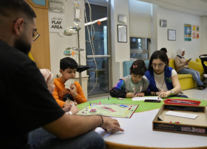 Carol Zeghayer, 9, second right, a girl who suffers from leukaemia, attends with a volunteer who offers her a compassionate care and entertainment session ahead of her treatment at the Children's Cancer Center of Lebanon, in Beirut, Lebanon, Friday, Nov. 15, 2024. (AP Photo/Hussein Malla)