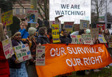 Activists protest outside the International Court of Justice, in The Hague, Netherlands, as it opens hearings into what countries worldwide are legally required to do to combat climate change and help vulnerable nations fight its devastating impact, Monday, Dec. 2, 2024. (AP Photo/Peter Dejong)