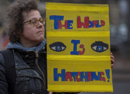 Activists protest outside the International Court of Justice, in The Hague, Netherlands, as it opens hearings into what countries worldwide are legally required to do to combat climate change and help vulnerable nations fight its devastating impact, Monday, Dec. 2, 2024. (AP Photo/Peter Dejong)