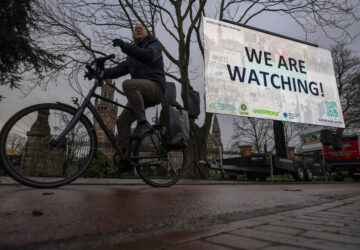 Activists put up a billboard outside the International Court of Justice, in The Hague, Netherlands, as it opens hearings into what countries worldwide are legally required to do to combat climate change and help vulnerable nations fight its devastating impact, Monday, Dec. 2, 2024. (AP Photo/Peter Dejong)