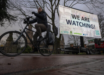 Activists put up a billboard outside the International Court of Justice, in The Hague, Netherlands, as it opens hearings into what countries worldwide are legally required to do to combat climate change and help vulnerable nations fight its devastating impact, Monday, Dec. 2, 2024. (AP Photo/Peter Dejong)