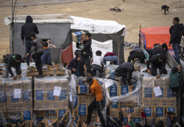 FILE - Palestinians grab humanitarian aid from a truck as it crossed into the Gaza Strip in Rafah, Dec. 17, 2023. (AP Photo/Fatima Shbair, File)