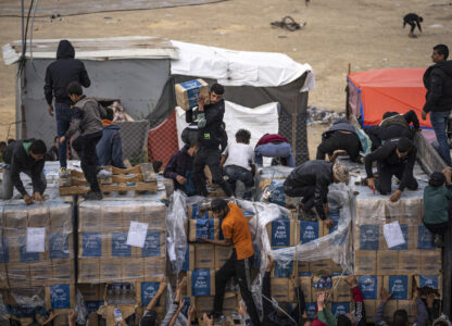 FILE - Palestinians grab humanitarian aid from a truck as it crossed into the Gaza Strip in Rafah, Dec. 17, 2023. (AP Photo/Fatima Shbair, File)