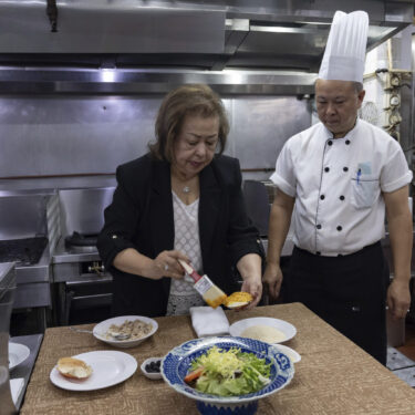 Manuela Sales da Silva Ferreira, owner of the family-run Restaurante Litoral, puts egg yolk on a crabmeat shell in a kitchen of her restaurant in Macao, on Nov. 11, 2024. (AP Photo/Anthony Kwan)