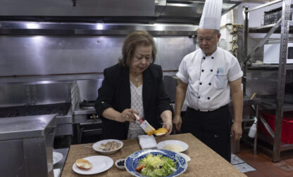 Manuela Sales da Silva Ferreira, owner of the family-run Restaurante Litoral, puts egg yolk on a crabmeat shell in a kitchen of her restaurant in Macao, on Nov. 11, 2024. (AP Photo/Anthony Kwan)