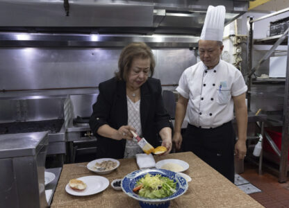 Manuela Sales da Silva Ferreira, owner of the family-run Restaurante Litoral, puts egg yolk on a crabmeat shell in a kitchen of her restaurant in Macao, on Nov. 11, 2024. (AP Photo/Anthony Kwan)