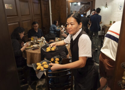 A waitress serves orders of cod fish cakes during lunch hour at a family-run Restaurante Litoral in Macao, on Nov. 11, 2024. (AP Photo/Anthony Kwan)