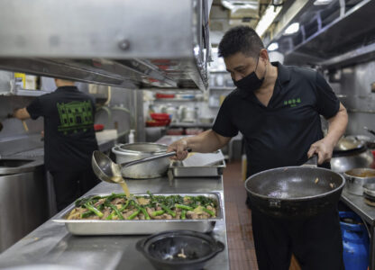 A staff member pours sauce onto a traditional local casserole called Tacho, made up of chicken, Chinese-style air dried pork sausages and local vegetables, at the family-run Restaurante Litoral in Macao, on Nov. 11, 2024. (AP Photo/Anthony Kwan)