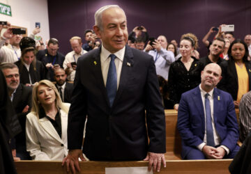 Israeli Prime Minister Benjamin Netanyahu, center, arrives to attend a hearing at the district court for his long-running trial for alleged corruption, in Tel Aviv, Israel, Tuesday, Dec. 10, 2024. (Menahem Kahana/Pool Photo via AP)