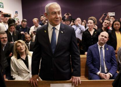 Israeli Prime Minister Benjamin Netanyahu, center, arrives to attend a hearing at the district court for his long-running trial for alleged corruption, in Tel Aviv, Israel, Tuesday, Dec. 10, 2024. (Menahem Kahana/Pool Photo via AP)