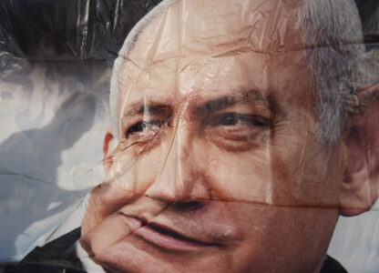 Supporters of Israel's Prime Minster Benjamin Netanyahu, seen in poster, gather outside a court in Tel Aviv, Israel, Tuesday, Dec. 10, 2024 as Netanyahu is set to take the stand in his long-running trial on corruption charges. (AP Photo/Ariel Schalit)