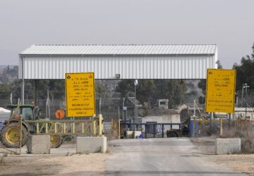 An Israel soldier sits next to a security fence gate near the Syrian side of the Quneitra crossing, between Israel and Syria, as seen from the Israeli-annexed Golan Heights, Wednesday, Dec. 11, 2024. (AP Photo/Matias Delacroix)