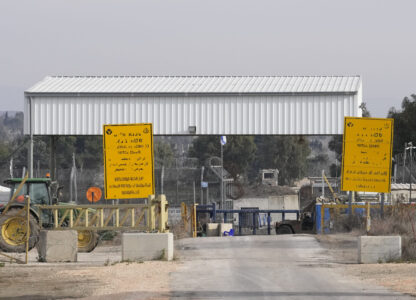 An Israel soldier sits next to a security fence gate near the Syrian side of the Quneitra crossing, between Israel and Syria, as seen from the Israeli-annexed Golan Heights, Wednesday, Dec. 11, 2024. (AP Photo/Matias Delacroix)