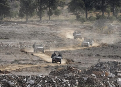 Israeli armoured vehicles maneuver next to the security fence near the so-called Alpha Line that separates the Israeli-annexed Golan Heights from Syria, in the town of Majdal Shams, Wednesday, Dec. 11, 2024. (AP Photo/Matias Delacroix)