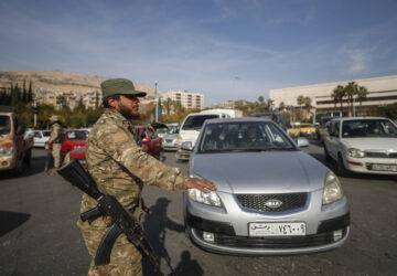 Syrian opposition fighters direct traffic in Damascus, Syria, Tuesday, Dec. 10, 2024. (AP Photo/Omar Sanadiki)