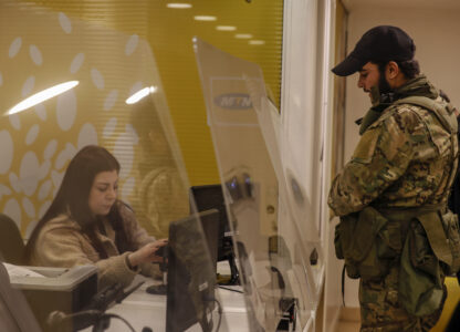 A Syrian opposition fighter waits to charge his mobile phone in Damascus, Syria, Tuesday, Dec. 10, 2024. (AP Photo/Omar Sanadiki)