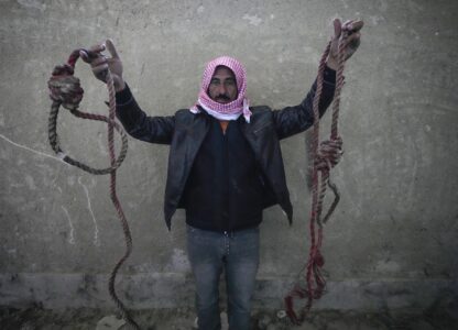 A man shows two ropes tied in the shape of nooses, found in the infamous Saydnaya military prison, just north of Damascus, Syria, Monday, Dec. 9, 2024. Crowds are gathering to enter the prison, known as the 