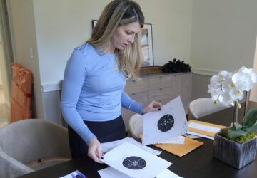 Grace Boutot, who won a silver medal in the Youth World Championships in 2009, displays targets from her time as a biathlon competitor, at her home in Boston, Oct. 17, 2024. (AP Photo/Steven Senne)