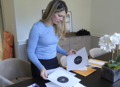 Grace Boutot, who won a silver medal in the Youth World Championships in 2009, displays targets from her time as a biathlon competitor, at her home in Boston, Oct. 17, 2024. (AP Photo/Steven Senne)