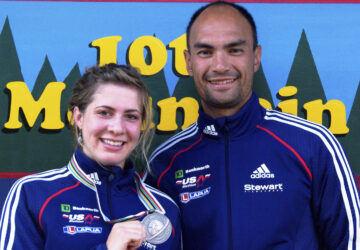 In this 2009 photo provided by Karen Gorman, biathlete Grace Boutot, left, of Fort Kent, Maine, displays her silver medal from the Youth Women Biathlon World Championships, while standing with coach Gary Colliander, right, in Fort Kent. (Karen Gorman via AP)