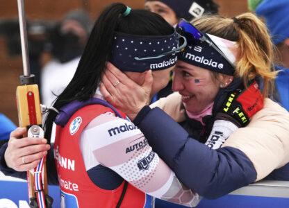 FILE — Joanne Reid, left, of the United States, and compatriot Deedra Irwin embrace at the finish line during the women's 4 x 6 km relay race at the biathlon World Cup in Anterselva, Italy, Jan. 22, 2022. (AP Photo/Matthias Schrader, File)