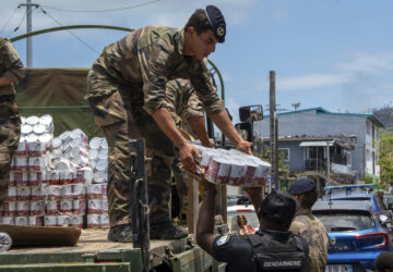 This photo provided by the French Army shows a soldier unloading cans of food in the Indian Ocean French territory of Mayotte, Wednesday Dec.18, 2024, as the cyclone on Saturday was the deadliest storm to strike the territory in nearly a century. (D Piatacrrea, Etat Major des Armees/Legion Etrangere via AP)