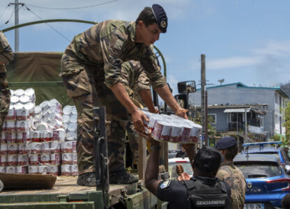 This photo provided by the French Army shows a soldier unloading cans of food in the Indian Ocean French territory of Mayotte, Wednesday Dec.18, 2024, as the cyclone on Saturday was the deadliest storm to strike the territory in nearly a century. (D Piatacrrea, Etat Major des Armees/Legion Etrangere via AP)