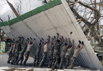 This photo provided by the French Army shows soldiers lifting a collapsed barrier in the Indian Ocean French territory of Mayotte, Wednesday Dec.18, 2024, as the cyclone on Saturday was the deadliest storm to strike the territory in nearly a century. (D Piatacrrea, Etat Major des Armees/Legion Etrangere via AP)