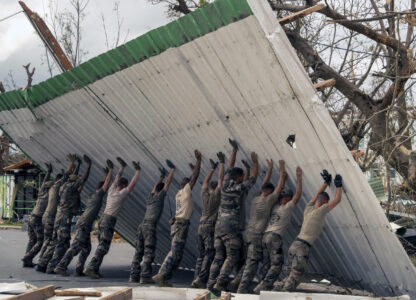 This photo provided by the French Army shows soldiers lifting a collapsed barrier in the Indian Ocean French territory of Mayotte, Wednesday Dec.18, 2024, as the cyclone on Saturday was the deadliest storm to strike the territory in nearly a century. (D Piatacrrea, Etat Major des Armees/Legion Etrangere via AP)