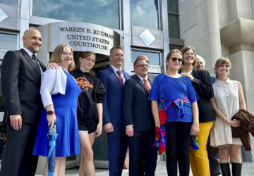 FILE - Two teens challenging New Hampshire's new law banning transgender girls from girls' sports teams pose with their families and attorneys in Concord, N.H., Monday, Aug. 19, 2024, after a judge granted an emergency request to allow one of the girls to play soccer while their lawsuit continues. (AP Photo/Holly Ramer, File)