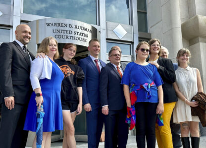 FILE - Two teens challenging New Hampshire's new law banning transgender girls from girls' sports teams pose with their families and attorneys in Concord, N.H., Monday, Aug. 19, 2024, after a judge granted an emergency request to allow one of the girls to play soccer while their lawsuit continues. (AP Photo/Holly Ramer, File)