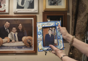 Debbie Marcus shows a framed photo of her son, Dov Marcus, taken at his Bar Mitzvah on display at their family home in Teaneck, N.J., on Friday, Dec. 20, 2024. (AP Photo/Luis Andres Henao)