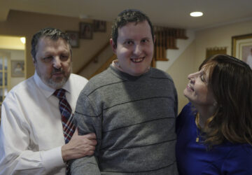 Dov Marcus smiles flanked by his parents, Robert Marcus and Debbie Marcus, in Teaneck, N.J., on Friday, Dec. 20, 2024. (AP Photo/Luis Andres Henao)