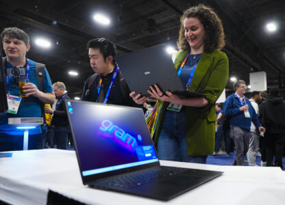 Rebecca Isaacs checks out the new LG gram 2-in-1 convertible laptop offering the versatility of both a laptop and tablet during 2025 CES Unveiled, Sunday, Jan. 5, 2025, in Las Vegas. (AP Photo/Jack Dempsey)